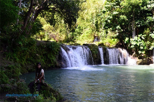 A lovely model sitting by the falls