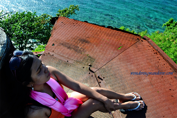 Girl sitting on top of rusty old Guisi Lighthouse - Guimaras