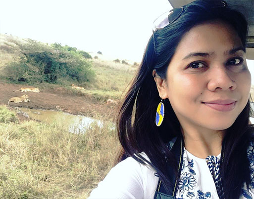 A girl having a selfie with two lions during a Kenya Safari
