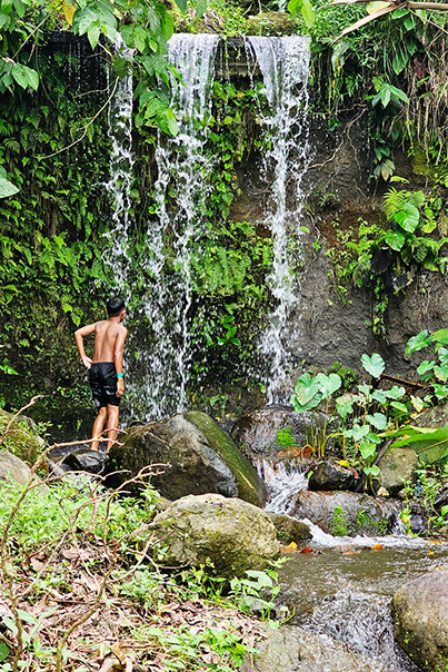 A boy watching a waterfall in Bantug Lake Farm